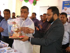 Dr. Enayet Karim handing over a memento to Expat Welfare Minister Engr. Khondker Mosharraf Hossain in a function